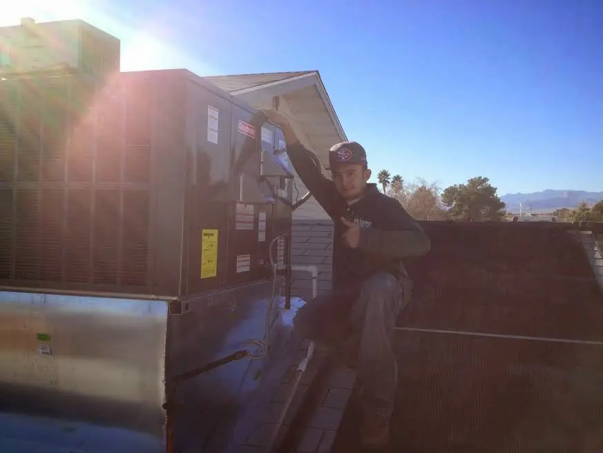 HVAC technician performing Air Duct Cleaning on a rooftop unit in Dickson City